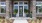 Entrance to The Prose Stevens Pointe apartments in St Cloud, featuring a path towards a stone archway and glass doors. 