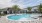 The pool area at our apartments in St Cloud, featuring reclining chairs, palm trees, and a view of the apartments. 