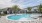 The pool area at our apartments in St Cloud, featuring reclining chairs, palm trees, and a view of the apartments. 