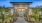 Entrance to The Prose Stevens Pointe apartments in St Cloud, featuring a path towards a stone archway and glass doors. 