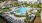 The pool area at our apartments in St Cloud, featuring reclining chairs, palm trees, and a view of the apartments. 